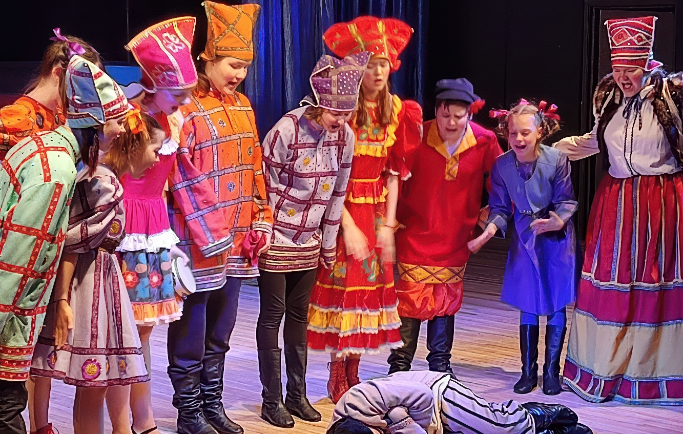 Актёры разных возрастов в традиционной одежде на сцене