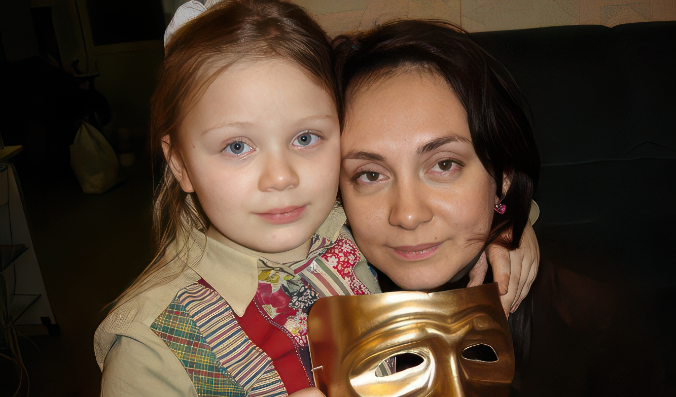 Актриса и девочка держут театральную маску