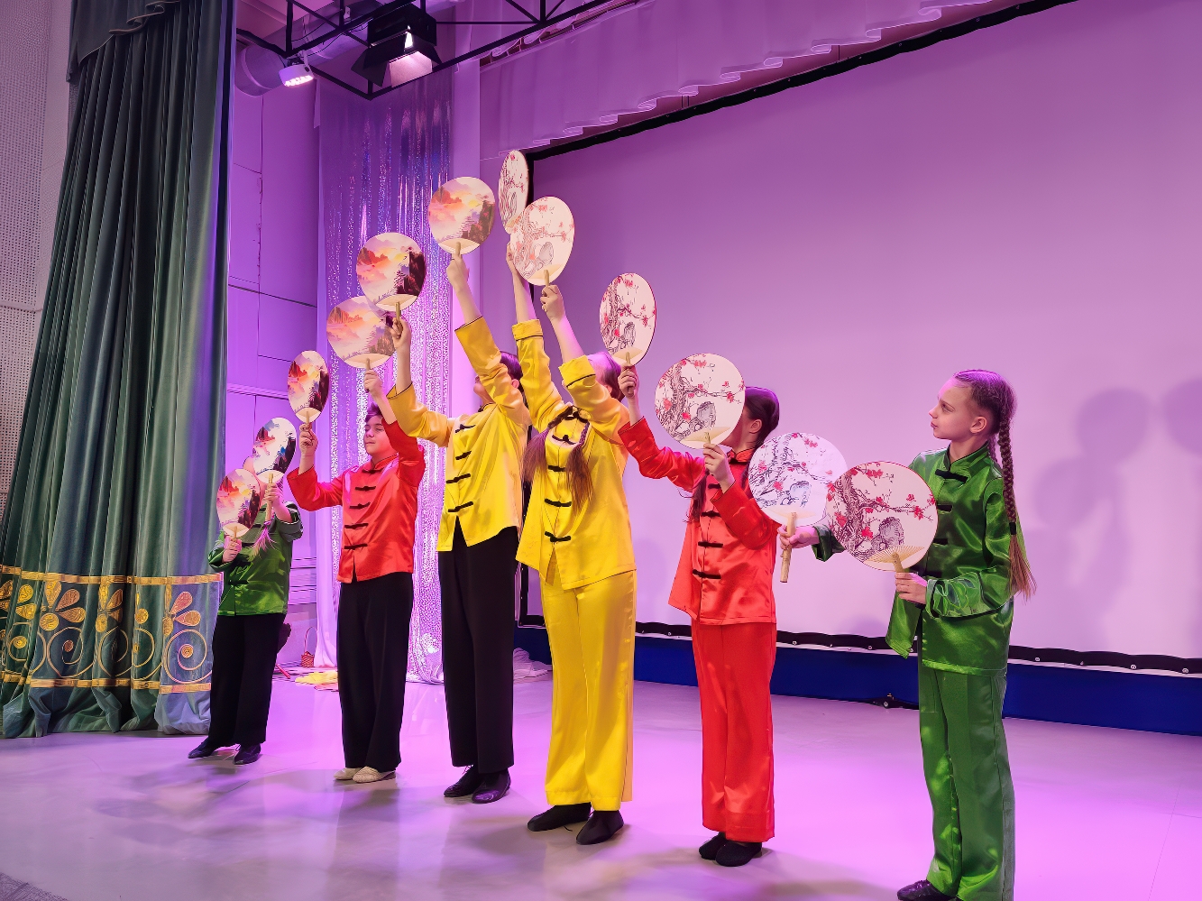 Дети на сцене танцуют с тарелками